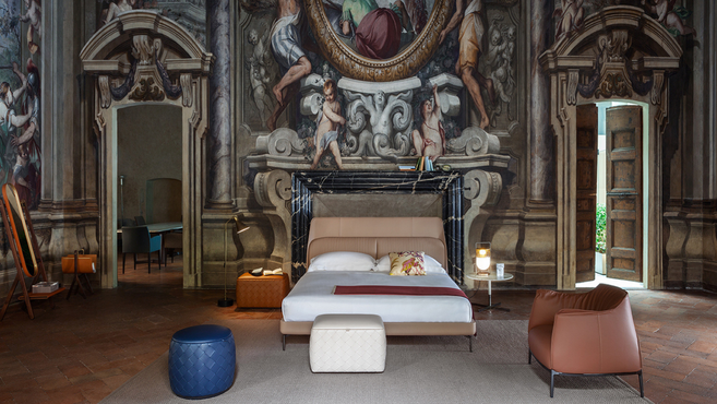 Coupe bed by Poltrona Frau designed by GamFratesi styled within an architectural interior highlighting the refined designer bedroom furniture