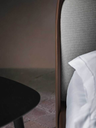 Angled view of the Coupé bed headboard and frame showing the transition between surfaces and refined stitching
