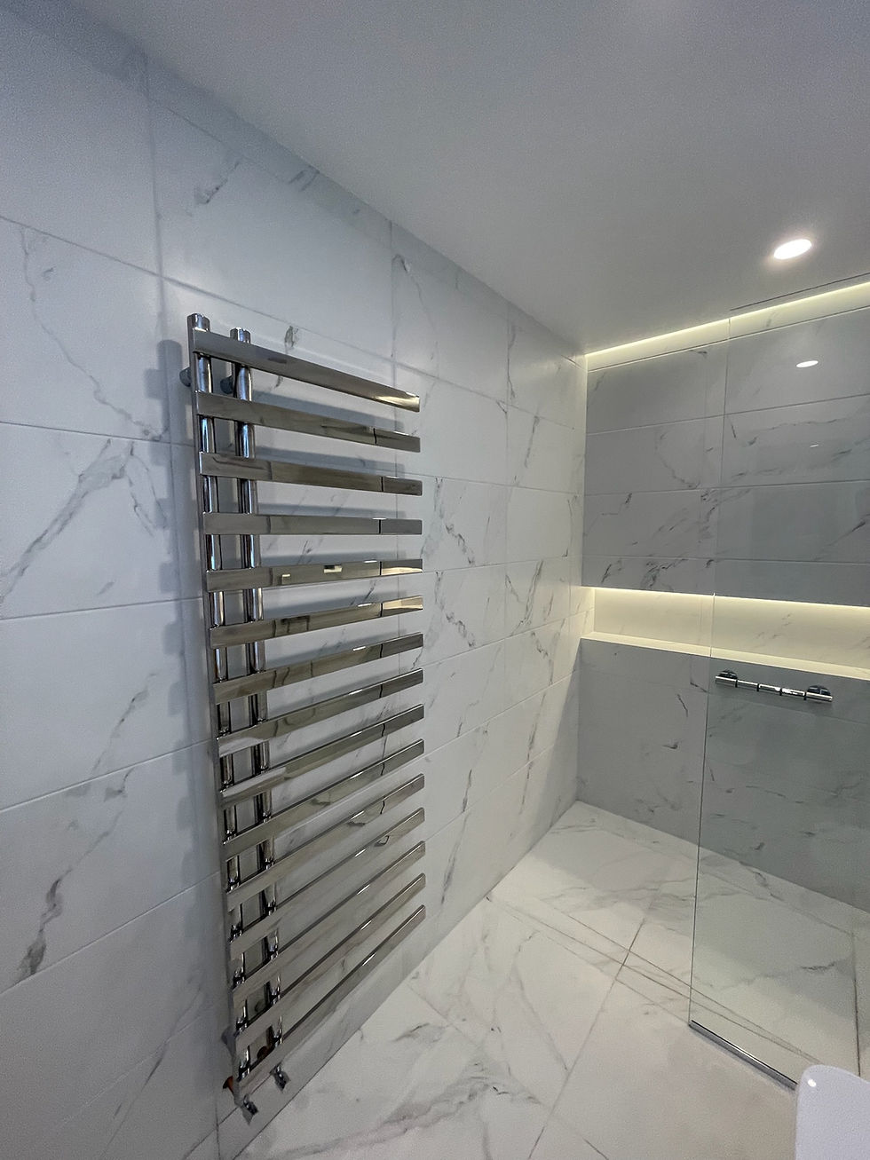 Large-format porcelain tiled shower enclosure with chrome fittings
