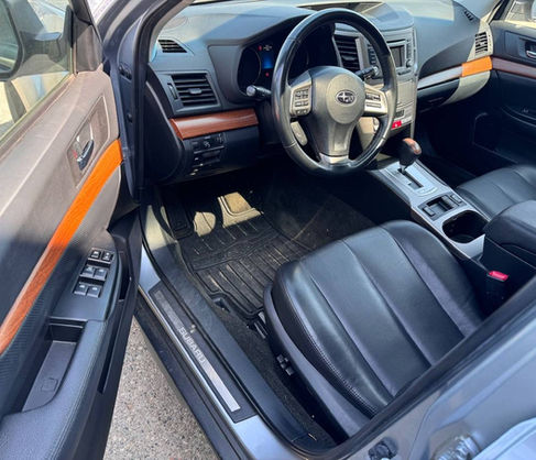 Interior view of a Subaru car, with steering wheel, dashboard, and seats