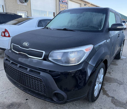 Black Kia Soul, parked outside on a sunny day.