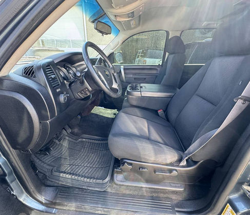 Inside truck view, black seats, steering wheel, dashboard, and side mirrors present.