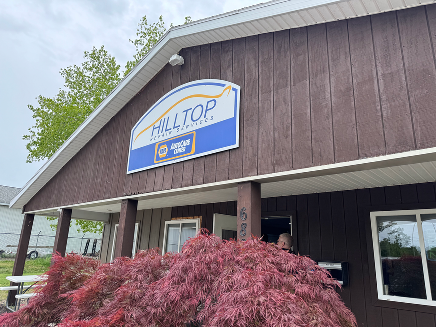 Hilltop Auto Service sign on a brown building
