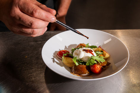 Balsamico wird mit der Pipette auf Burrata geträufelt
