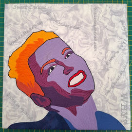 This is a quilted piece of Annie Lennox, a portrait, using brightly colored fabrics, and shadows to define areas of the face