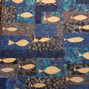 A photograph of a quilt featuring fish