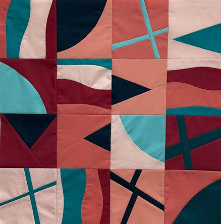 This is a photograph of a quilted piece with several small squares of fabric in tan, black and teal blue