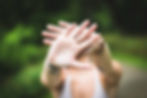 A womans hands with palms facing outward as if to say no or back off.