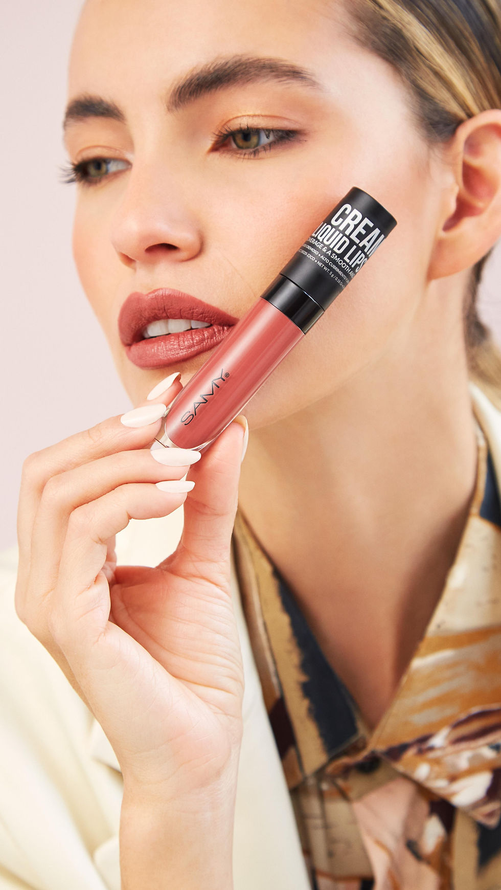 Vista frontal de modelo sosteniendo el labial liquido cremoso de samy