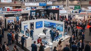 Panoramic view of the bustling MIPCOM 2025 exhibition floor in the Palais des Festivals, Cannes, with attendees networking and diverse content booths on display.