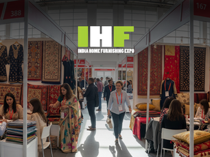 A bustling exhibition hall at the India Home Furnishing & Garment Fair, with buyers examining colorful Indian textiles and apparel.
