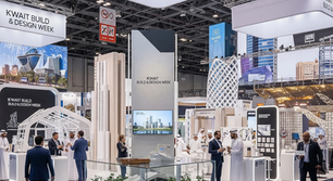 Wide shot of the Kuwait Build & Design Week event, showing a diverse crowd interacting with innovative construction technology displays and modern interior design setups.