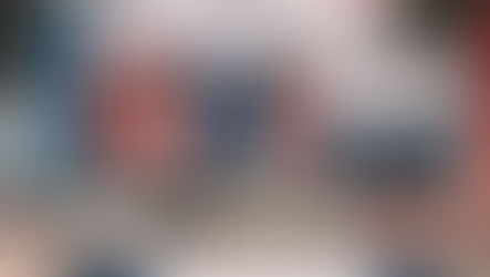 Hanging banners at a trade show in Frankfurt, featuring "AMBIENTE FRANKFURT" text. Colorful displays amid an industrial venue.