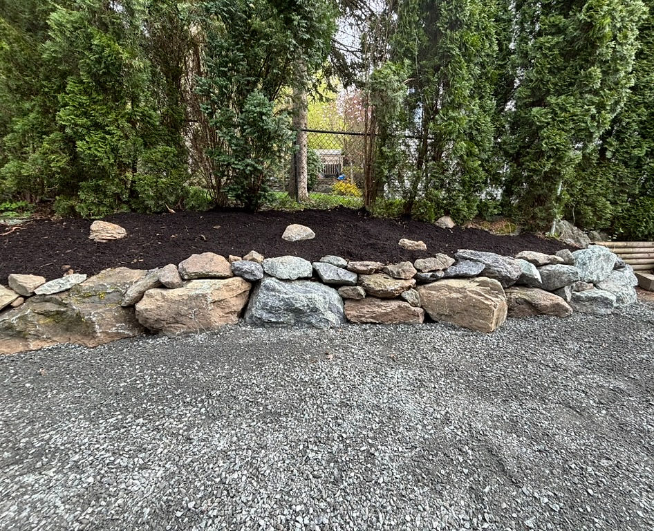 Natural stone retaining wall built on sloped yard