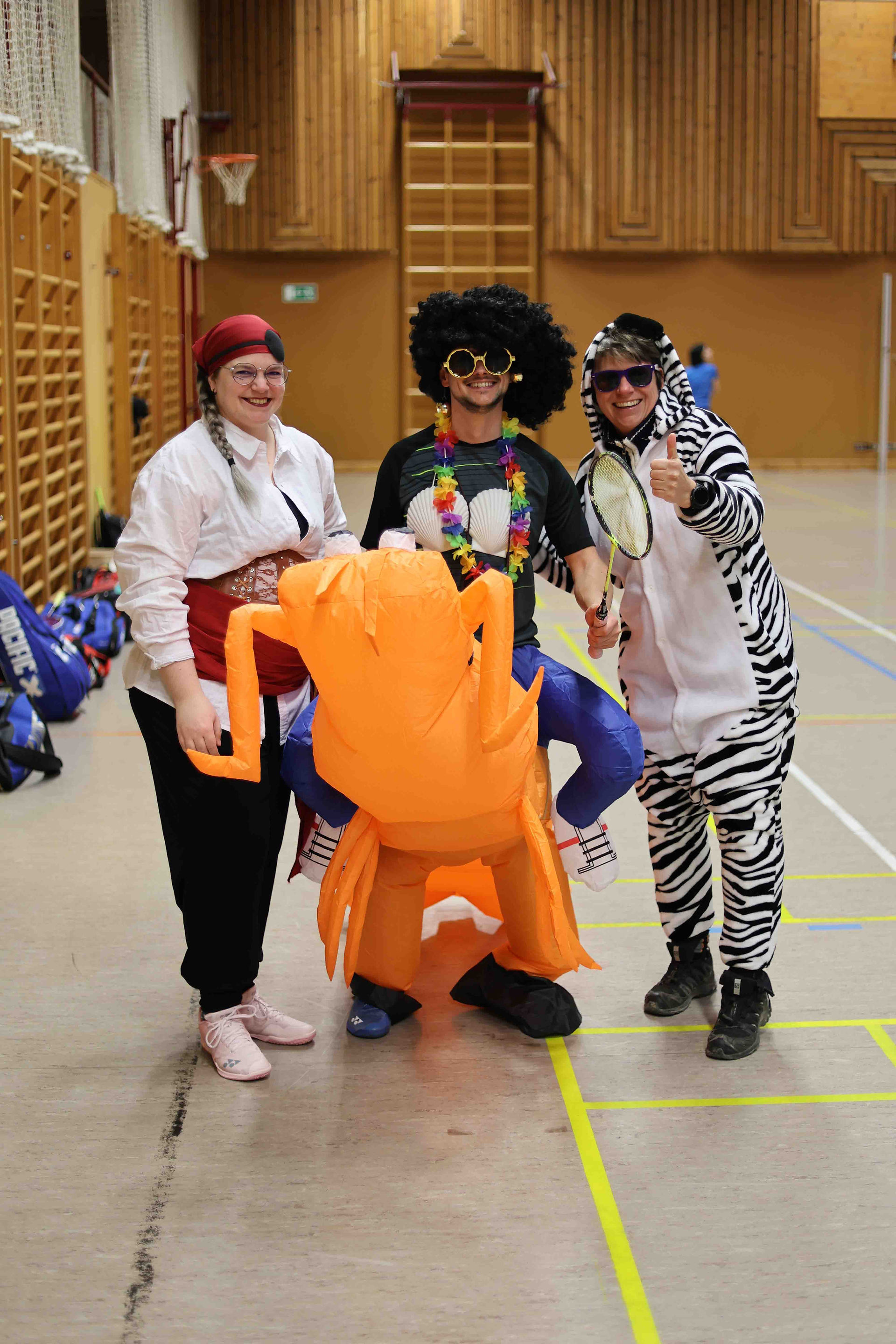 Kostümierte Spieler im Badmintontraining (Pirat, Mann auf Shrimp und Zebra)