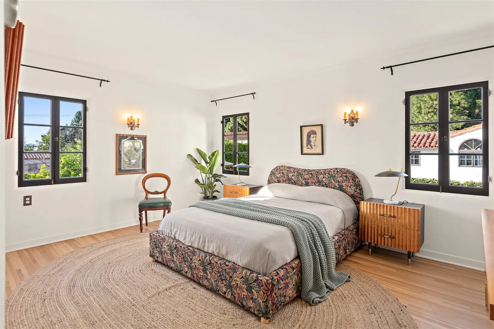Bedroom with restored hardwood floors and dark-framed windows at 1239 Geneva Street