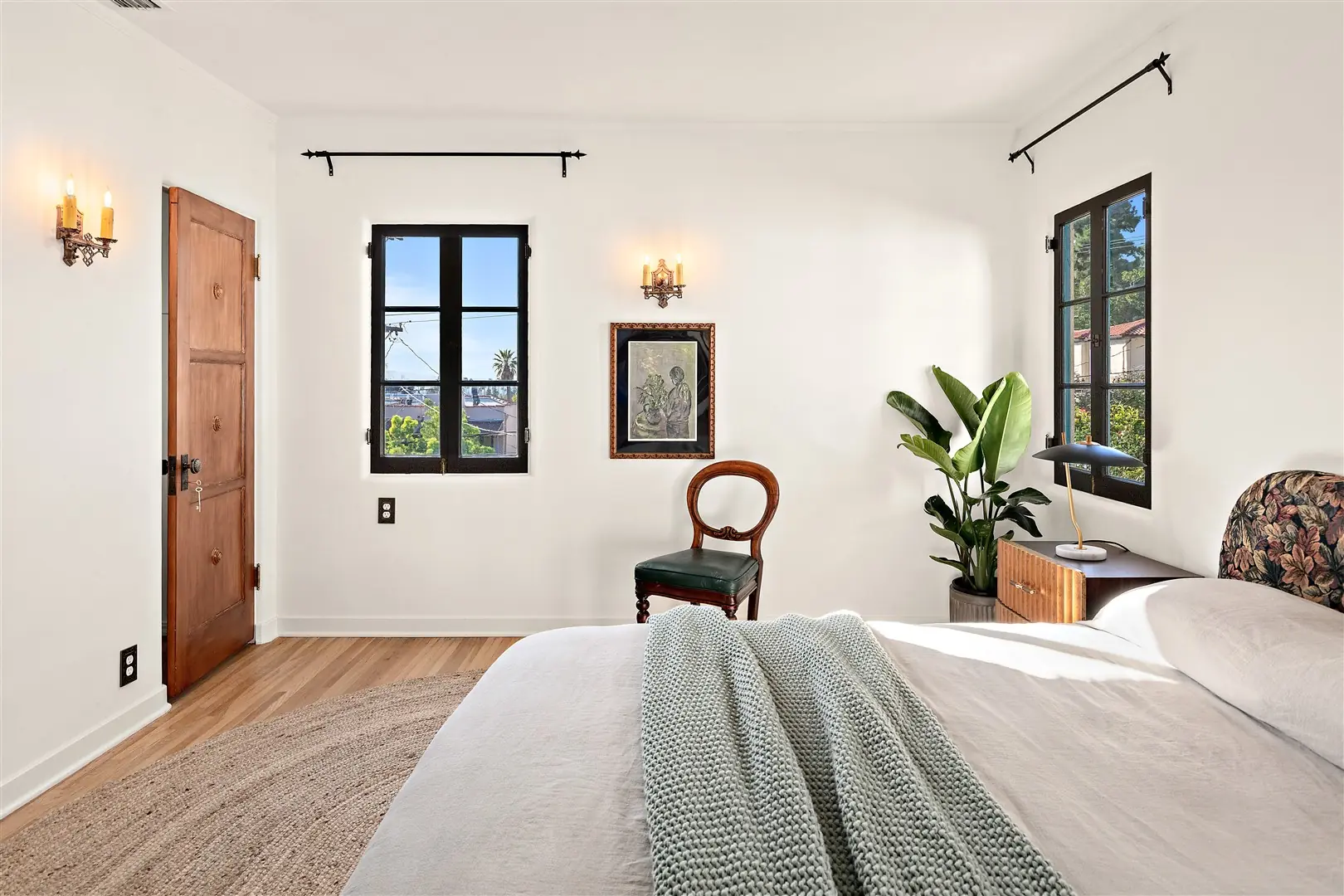 Bedroom with restored hardwood floors and dark-framed windows at 1239 Geneva Street