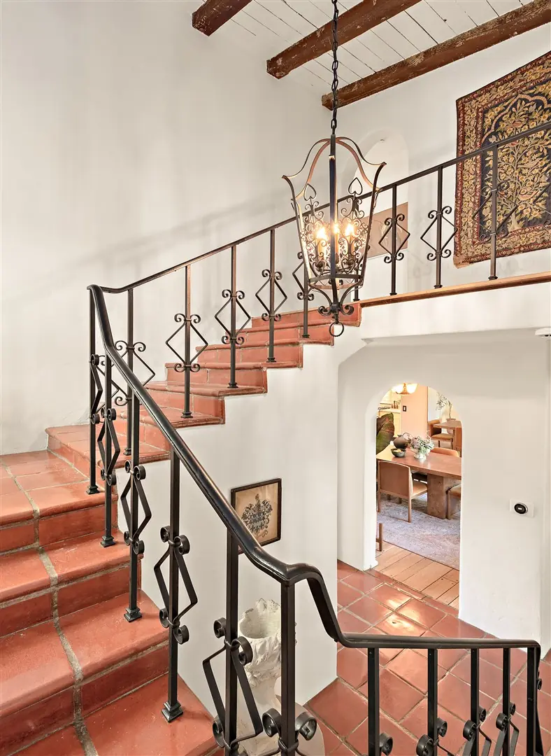 Central stair with terracotta treads, iron railing, and stained glass at 1239 Geneva Street