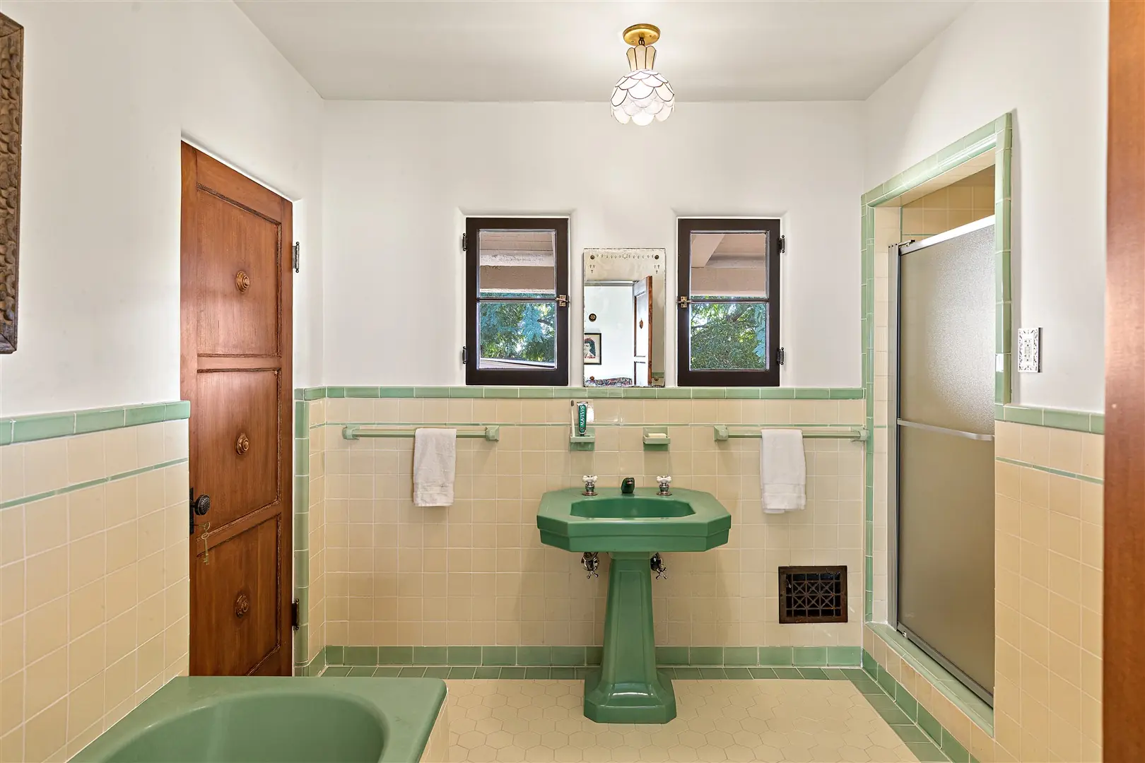 Original mint-green tile bathroom with pedestal sink at 1239 Geneva Street