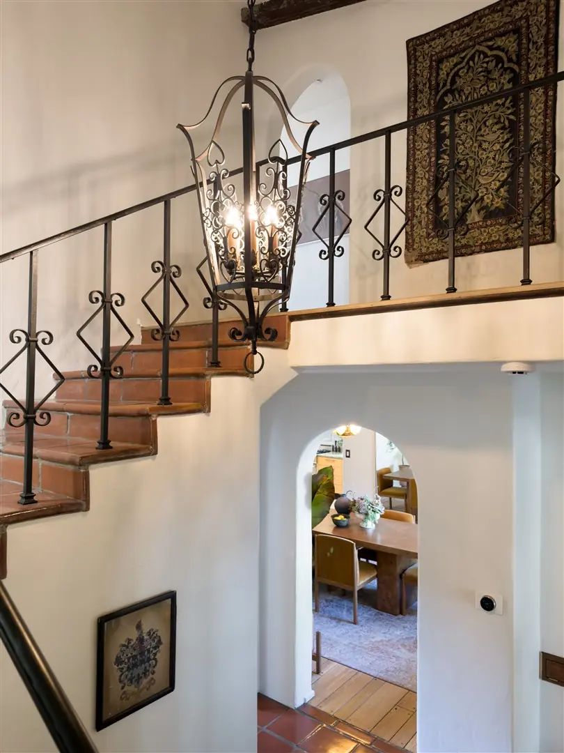 Central stair with terracotta treads, iron railing, and stained glass at 1239 Geneva Street