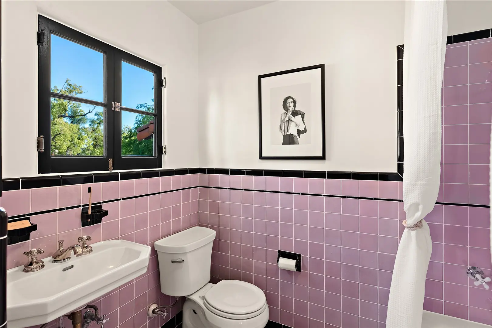 Original lavender tile bathroom with restored dark-framed window at 1239 Geneva Street