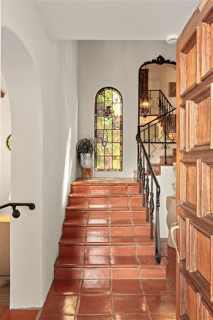 Stair hall with stained glass window and original wood details at 1239 Geneva Street