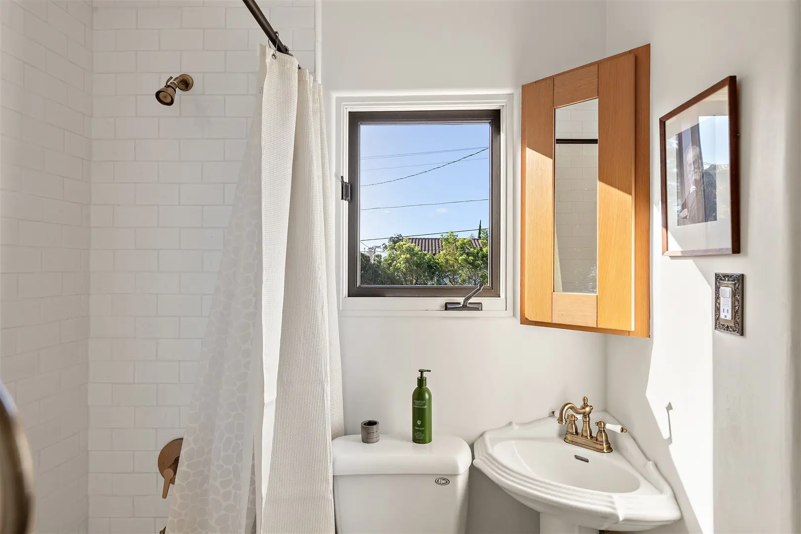 Bathroom sink beneath a restored casement window at 1239 Geneva Street