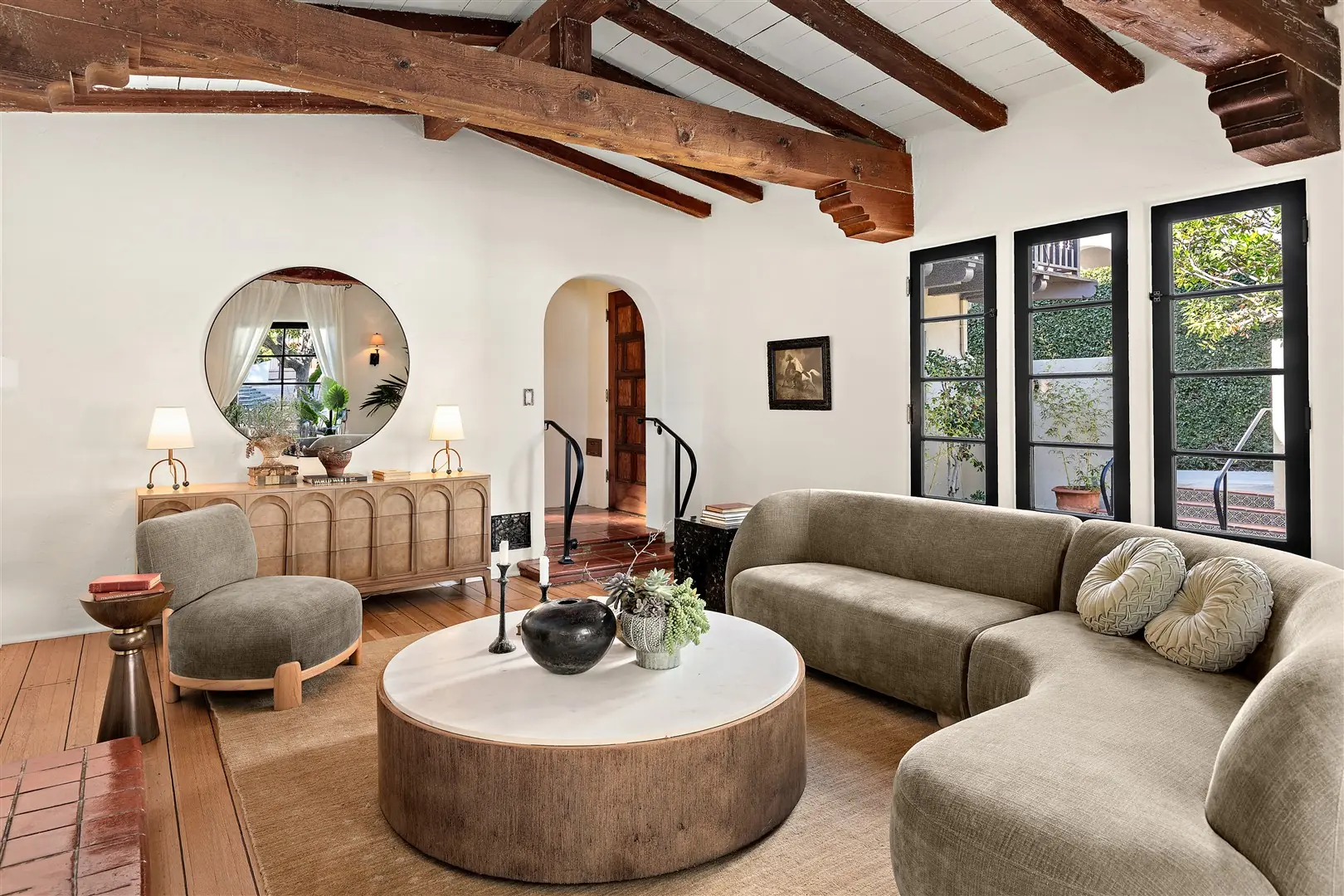 Living room with restored hardwood floors, plaster walls, and exposed beams at 1239 Geneva Street
