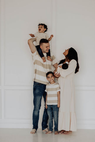 Family smiling in a photography studio during a family portrait session in Dallas, Texas