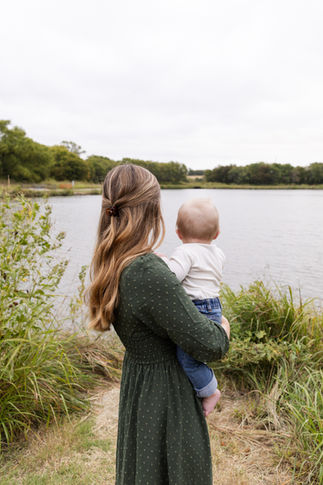 Mom holding baby during an outdoor family portrait session in Dallas, Texas