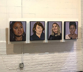 Four paintings of women hand on a white brick wall.