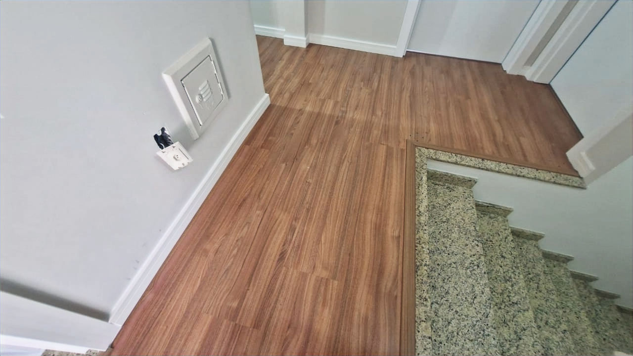 Vista superior de um piso de madeira e escada. Guara Construtora.