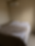Cama de casal arrumada em quarto com ar-condicionado.