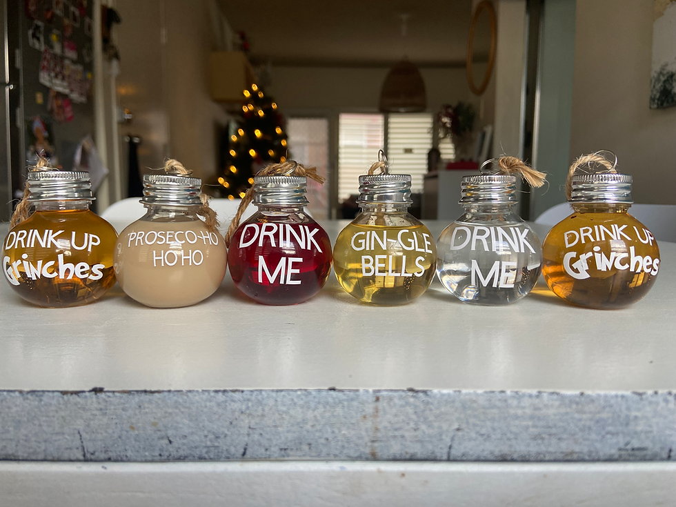 Thumbnail: Six small glass bottles with holiday texts on a white table.