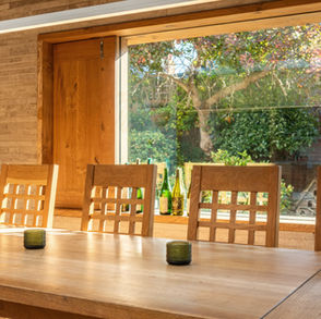 Architect designed sustainable extension to listed building.
Stone cladding. New build construction. a dining room with a table and chairs in it