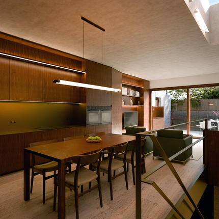 Modern mid century open plan kitchen living and dining room with green sofas.