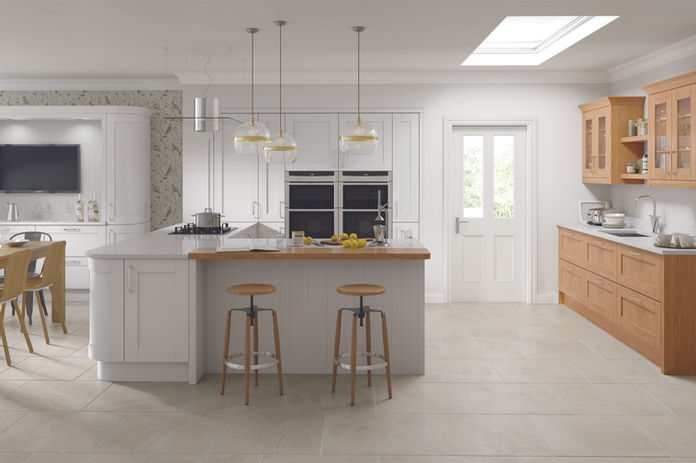 Modern kitchen interior with counter, stools, and overhead lighting.