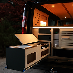 Das Bild zeigt das Heck unseres spree.campers bei geöffneter Heckklappe und ausgezogener Küchenschublade