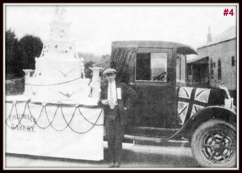 A b/w photo of a man circa 1920's standing in front of a truck decorated with a large cake