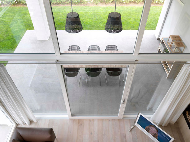 Alzanti scorrevoli e pareti vetrate in legno laccato bianco con rivestimento in alluminio