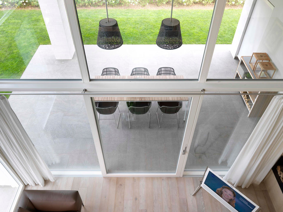 Alzanti scorrevoli e pareti vetrate in legno laccato bianco con rivestimento in alluminio