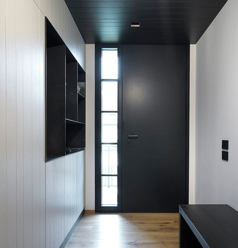 Portoncino in legno con fianco luce fisso con inglesine, finitura laccata nera lato interno e rivestimento in alluminio nero lato esterno