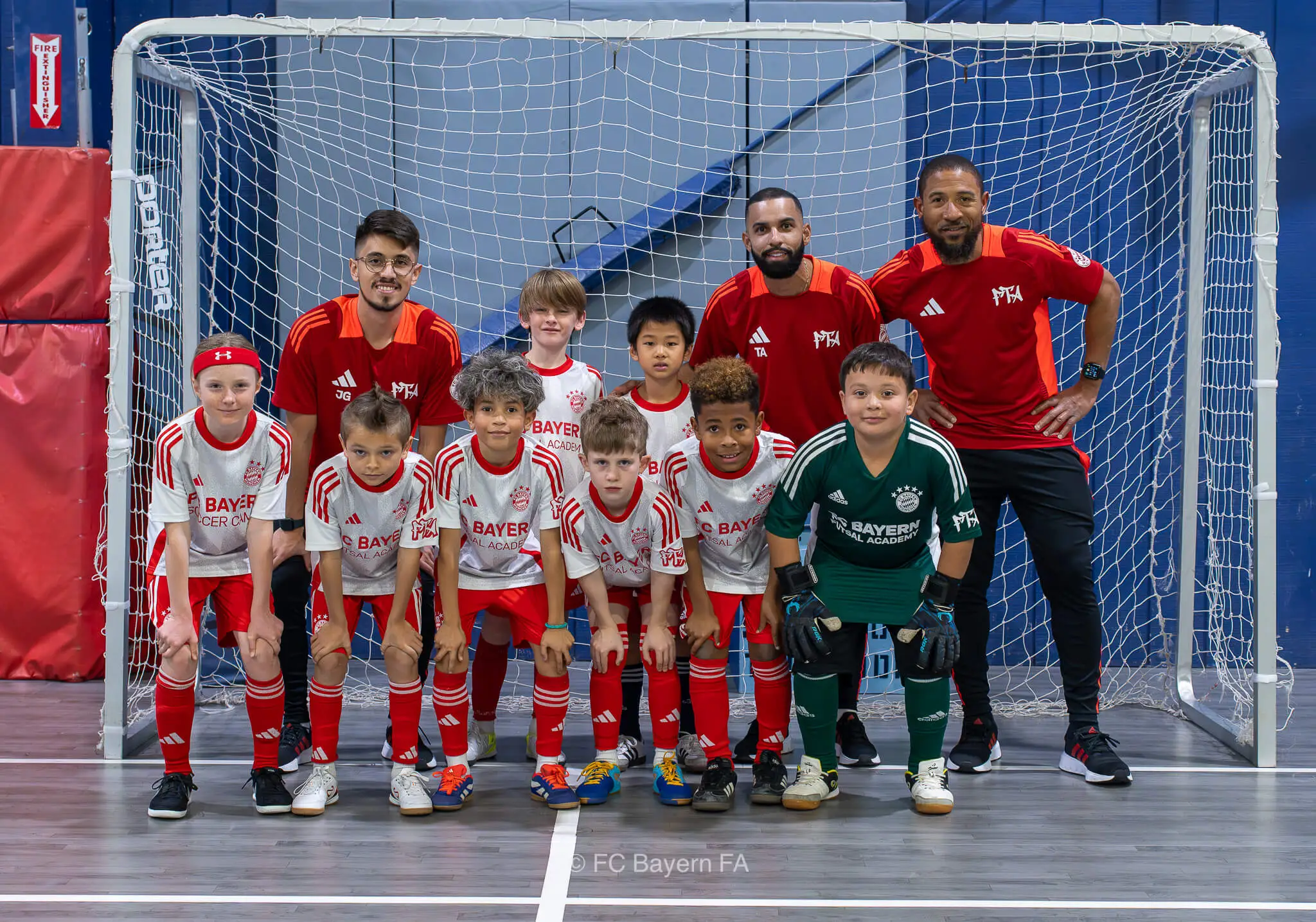 A group of kids from FC Bayern Futsal posing for a photo.