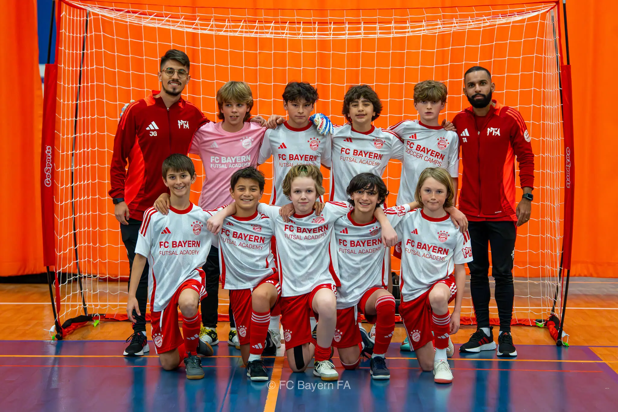 A group of kids from FC Bayern Futsal posing for a photo.