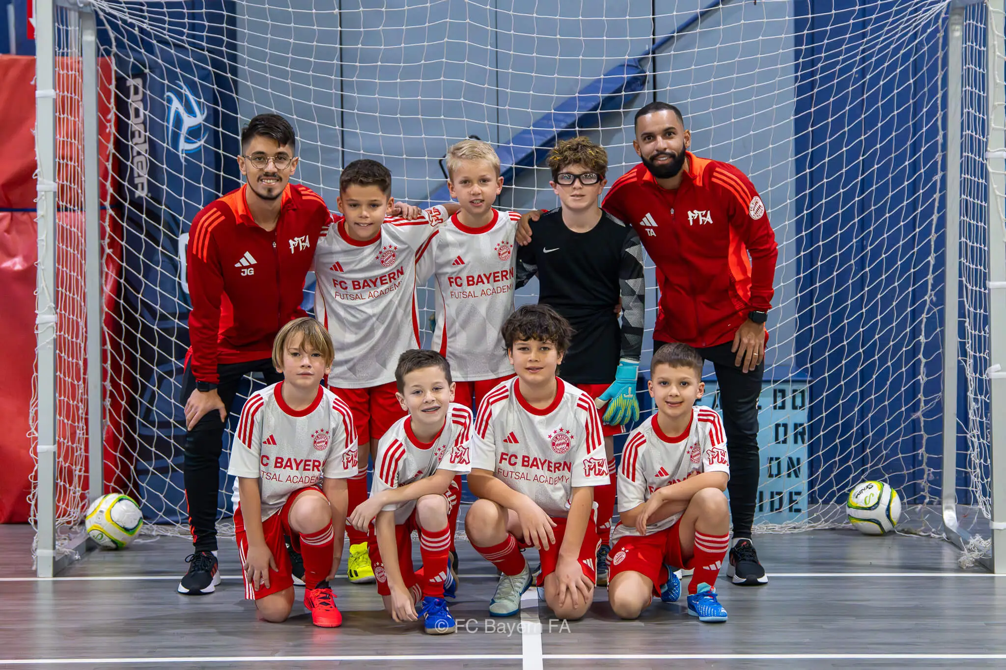 A group of kids from FC Bayern Futsal posing for a photo.