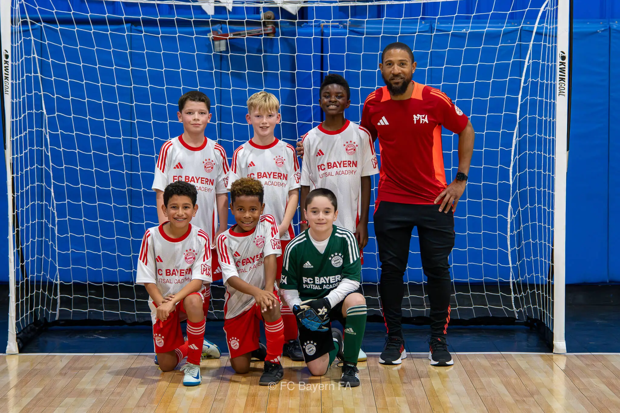 A group of kids from FC Bayern Futsal posing for a photo.
