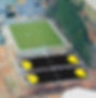 Aerial view of a grass soccer field and black multi-sport courts