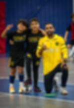 Two boys and futsal coach with a ball