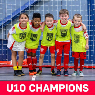 A group of kids hugging each other wearing FC Bayern Futsal Kits