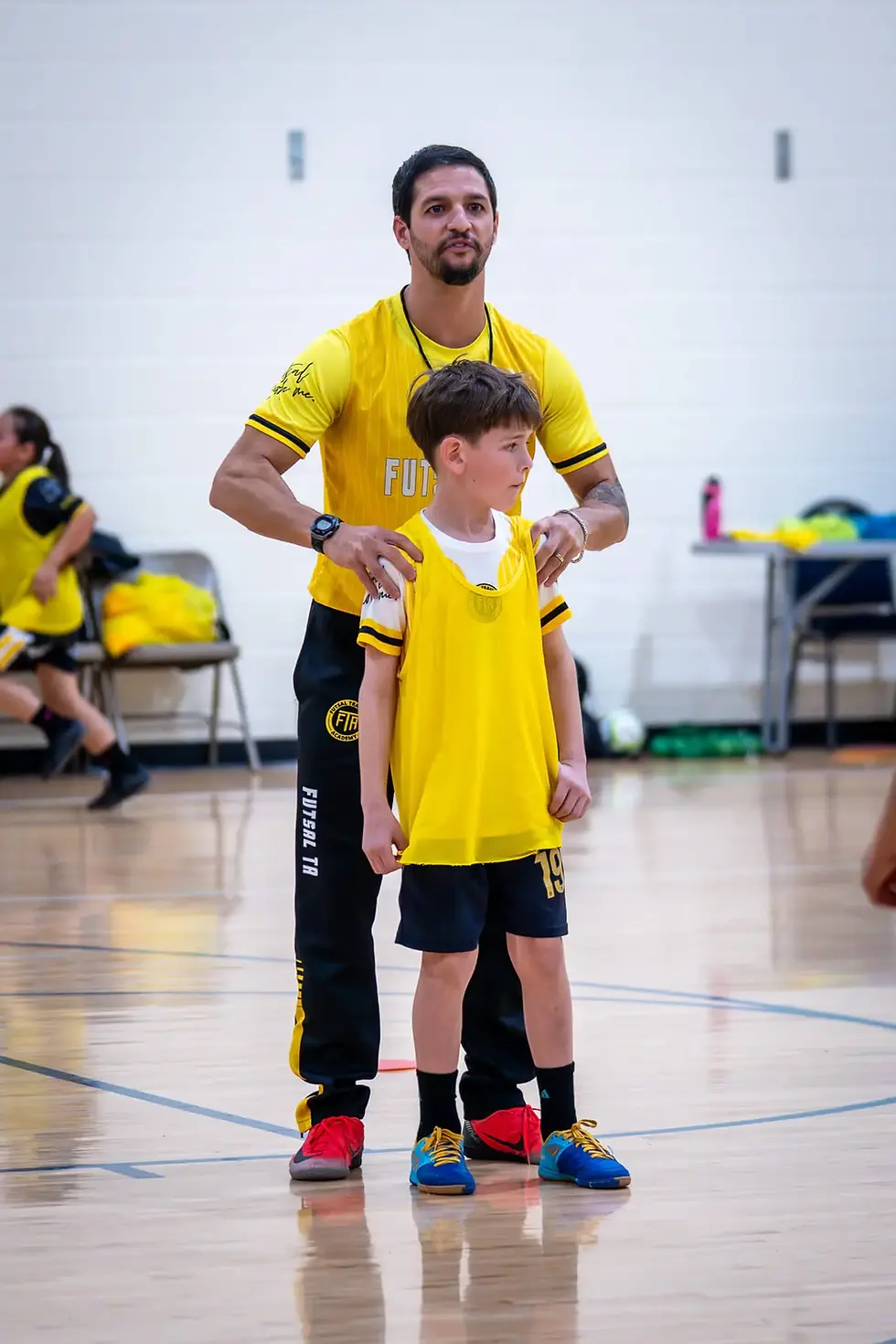 Summer program coach with boy in yellow jersey